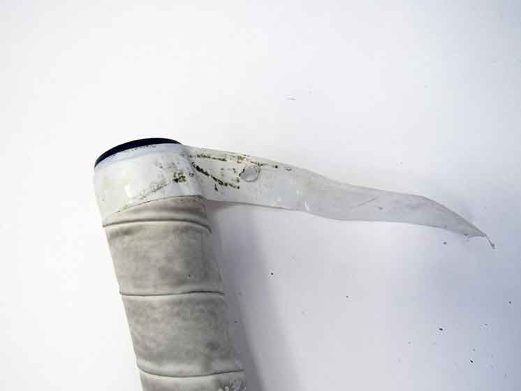 Stick tape peeling away from a field hockey stick.